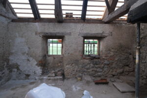 Restaurierung Waschhaus Lütishofer Chorhof, Beromünster LU. Die südliche Innenwand ist vom harten Zementputz befreit. Im linken Bildbereich ist die Musterfläche der Putzergänzung zu sehen.